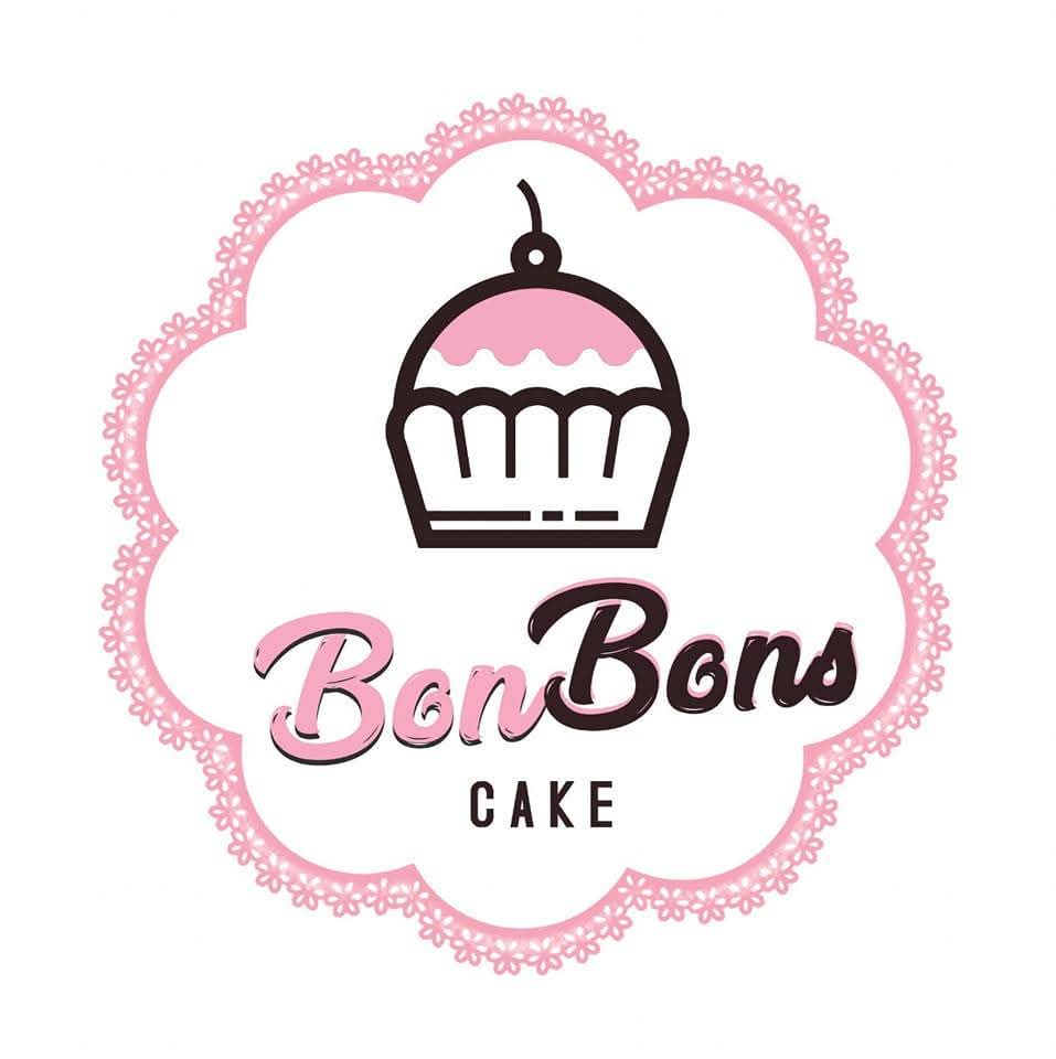 Overhead view of hands unboxing a cake with a white ribbon